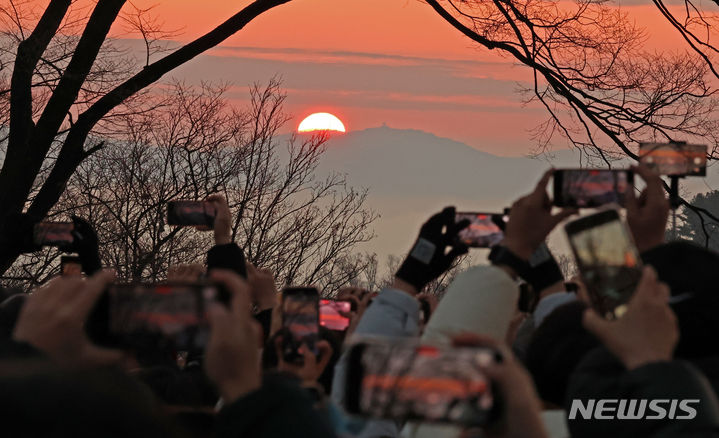 [서울=뉴시스] 김금보 기자 = 1일 오전 서울 중구 남산에서 해맞이객들이 새해 첫 일출을 보고 있다. 2024.01.01. kgb@newsis.com