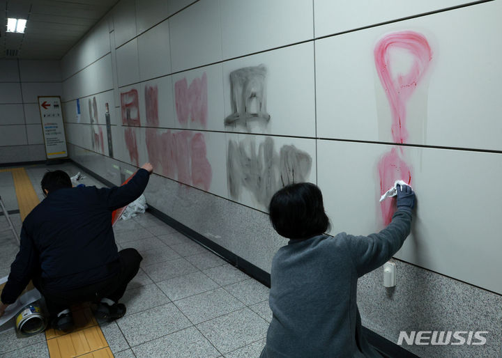 [서울=뉴시스] 고범준 기자 = 2일 오전 서울 영등포구 9호선 국회의사당역 6번출구 벽에 스프레이 낙서가 그려진 가운데 관계자들이 지우는 작업을 하고 있다. 2024.01.02. bjko@newsis.com