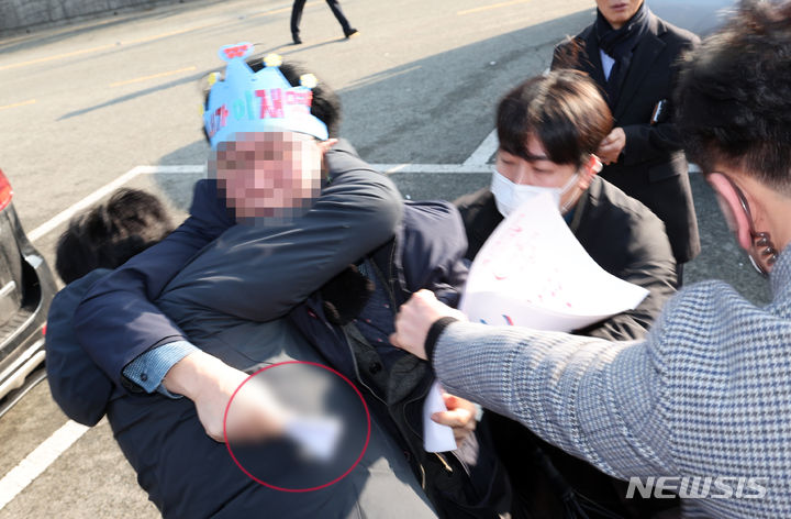 [부산=뉴시스] 하경민 기자 = 2일 오전 부산 강서구 대항전망대에서 이재명 더불어민주당 대표를 흉기로 피습한 용의자가 흉기를 든 채 경찰에 연행되고 있다. 2024.01.02. yulnetphoto@newsis.com