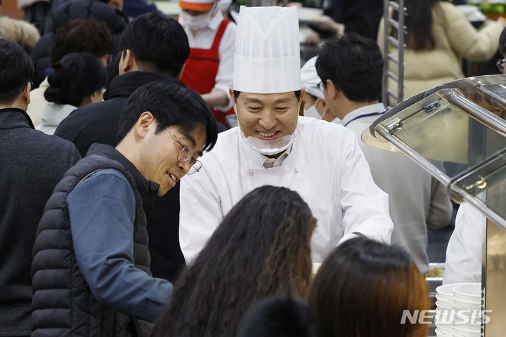 [서울=뉴시스] 김선웅 기자 = 오세훈 서울시장이 2일 서울시청 구내식당에서 신년을 맞아 떡국을 배식하며 직원들을 격려하고 있다. (공동취재) 2024.01.02. photo@newsis.com