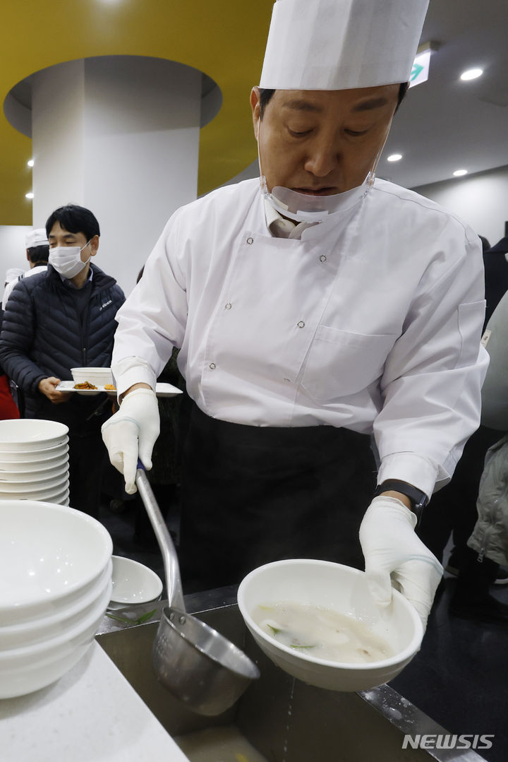 [서울=뉴시스] 김선웅 기자 = 오세훈 서울시장이 2일 서울시청 구내식당에서 신년을 맞아 떡국을 배식하며 직원들을 격려하고 있다. (공동취재) 2024.01.02. photo@newsis.com