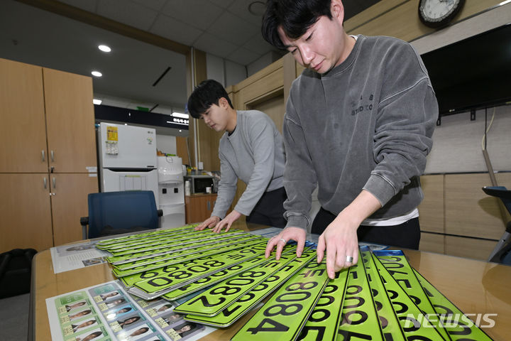 [광주=뉴시스] 이영주 기자 = 3일 오전 광주 서구 교통행정과 직원들이 고가 법인차량 사적 사용과 탈세를 막기 위해 도입된 연두색 차량 번호판을 정리하고 있다. 정부는 지난 1일부터 공공·민간법인에서 이용하는 취득가액 8000만원 이상 법인 업무용 승용차에 대한 연두색 차량 번호판 부착 제도를 시행하고 있다. 2024.01.03. leeyj2578@newsis.com