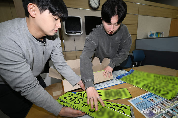 [광주=뉴시스] 이영주 기자 = 3일 오전 광주 서구 교통행정과 직원들이 고가 법인차량 사적 사용과 탈세를 막기 위해 도입된 연두색 차량 번호판을 정리하고 있다. 정부는 지난 1일부터 공공·민간법인에서 이용하는 취득가액 8000만원 이상 법인 업무용 승용차에 대한 연두색 차량 번호판 부착 제도를 시행하고 있다. 2024.01.03. leeyj2578@newsis.com