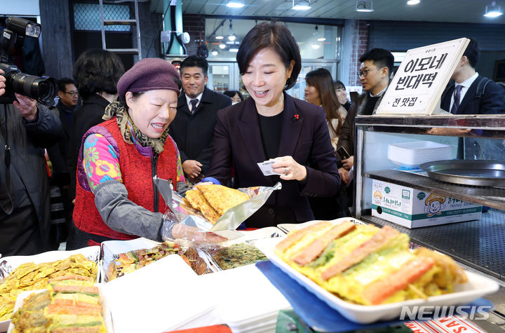 [서울=뉴시스] 홍효식 기자 = 오영주 중소벤처기업부 장관이 지난 1월 서울 용산구 용문시장 상인회 사무실에서 열린 소상공인·전통시장 협·단체 현장간담회를 마친 뒤 전을 구입하고 있다. 2024.07.05. yesphoto@newsis.com