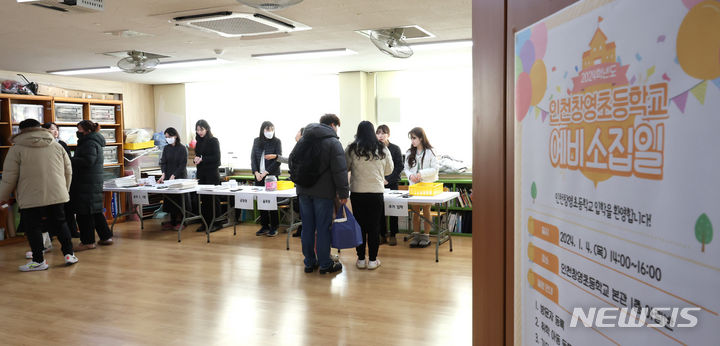 [인천=뉴시스] 전진환 기자 = 2024학년도 초등학교 신입생 예비소집일인 4일 오후 인천 동구 창영초등학교에서 학부모와 예비 초등학생이 선생님으로부터 안내문 등 서류를 받고 있다. 2024.01.04. amin2@newsis.com