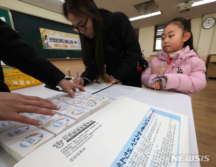 [인천=뉴시스] 전진환 기자 = 2024학년도 초등학교 신입생 예비소집일인 4일 오후 인천 동구 창영초등학교에서 학부모와 예비 초등학생이 서류를 작성하고 있다. 2024.01.04. amin2@newsis.com