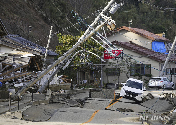 [이시카와=AP/뉴시스]새해 첫날 발생한 일본 노토(能登)반도 강진으로 현지 원자력발전소 15곳에서 방사선량 계측기 '모니터링 포스트'가 고장 등으로 측정할 수 없는 상태라고 5일 도쿄신문이 보도했다. 사진은 이날 이시카와현 와지마시에서 지진으로 도로가 파손돼 전봇대가 쓰러져 있는 모습. 2024.01.05.