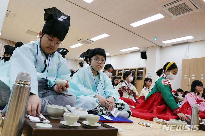 [부산=뉴시스] 하경민 기자 = 8일 오전 부산 동래구 충렬사 안락서원 교육회관에서 열린 '초등학생 겨울방학 전통문화 체험교실'에 참가한 초등생들이 한복을 곱게 차려입고 다도 예절을 배우고 있다. 초등학생 40여 명이 참가한 이번 체험교실에서는 다도 및 서당 체험과 민요 배우기, 민속놀이 체험 등을 오는 12일까지 진행한다. 2024.01.08. yulnetphoto@newsis.com