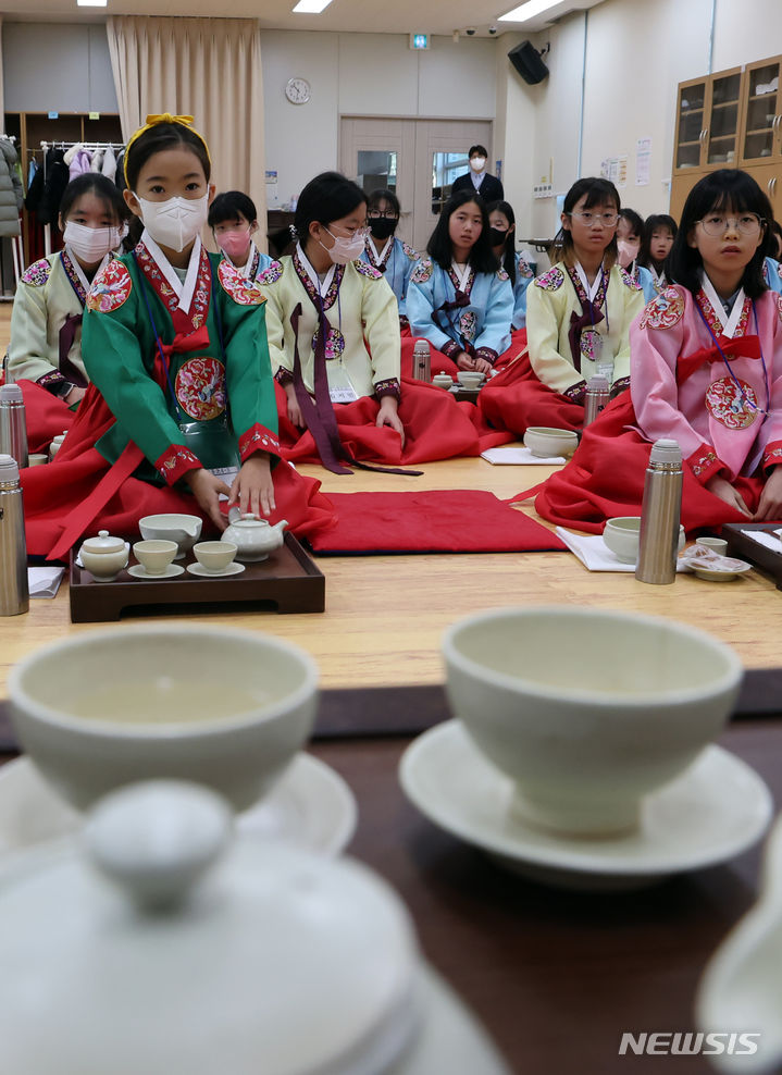 [부산=뉴시스] 하경민 기자 = 8일 오전 부산 동래구 충렬사 안락서원 교육회관에서 열린 '초등학생 겨울방학 전통문화 체험교실'에 참가한 초등생들이 한복을 곱게 차려입고 다도 예절을 배우고 있다. 초등학생 40여 명이 참가한 이번 체험교실에서는 다도 및 서당 체험과 민요 배우기, 민속놀이 체험 등을 오는 12일까지 진행한다. 2024.01.08. yulnetphoto@newsis.com