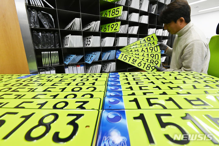 [수원=뉴시스] 김종택 기자 = 지난해 1월8일 경기도 수원시 권선구 수원도시공사 번호판제작소에서 직원이 고가 법인차량 사적 사용과 탈세를 막기 위해 도입된 연두색 차량 번호판을 정리하고 있다. 2024.01.08. jtk@newsis.com