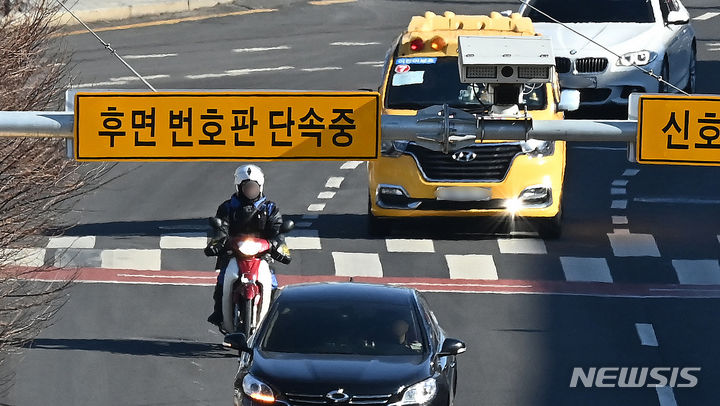 [수원=뉴시스] 경기도 수원시 한 도로에 설치된 후면 무인교통 단속 카메라 앞을 오토바이 운전자가 지나가고 있다. (사진= 뉴시스 DB) photo@newsis.com