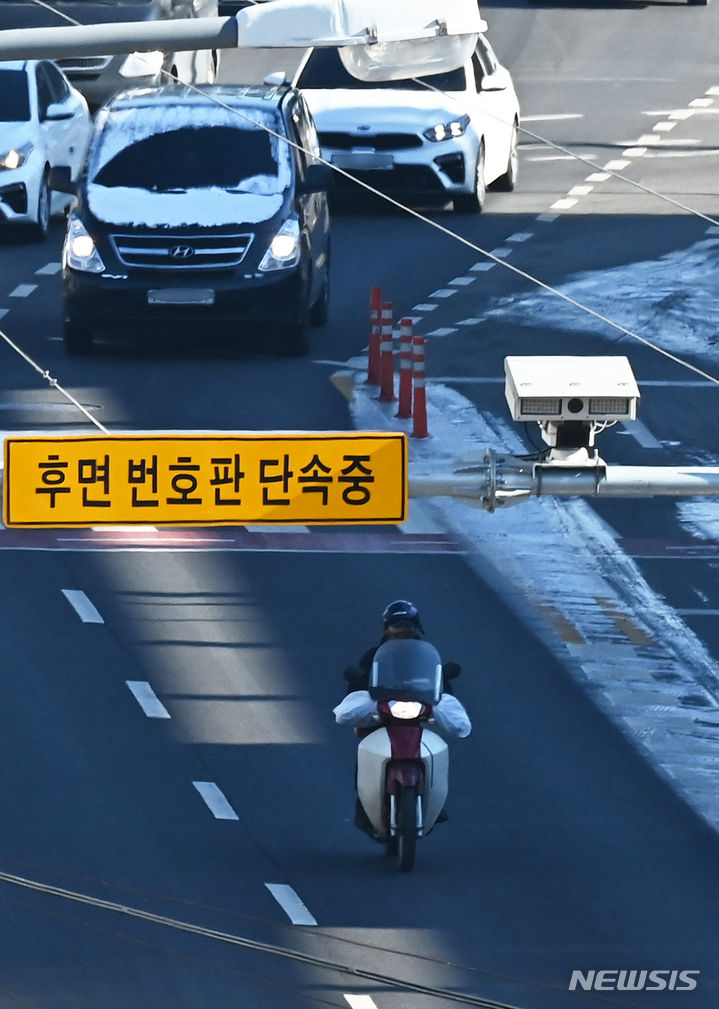 [수원=뉴시스] 김종택 기자 = 서울경찰청은 최근 5년간 무인 교통 단속카메라 설치 이후 서울시 전체 평균보다 교통사고는 2배, 교통 사망사고는 4배 이상 감소했다고 28일 밝혔다. 사진은 지난달 8일 경기도 수원시 한 도로에 설치된 후면 무인교통 단속 카메라 앞을 오토바이 운전자가 지나가고 있는 모습. 2024.01.08. jtk@newsis.com