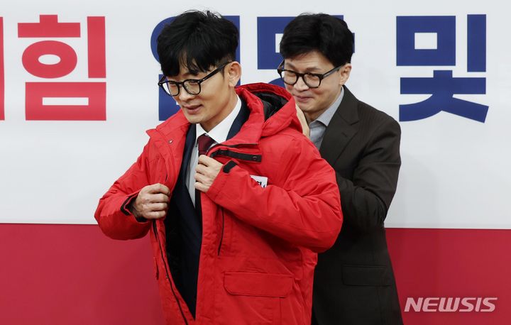 [서울=뉴시스] 조성봉 기자 = 한동훈 국민의힘 비상대책위원장이 8일 오전 서울 여의도 국회에서 열린 인재영입위원회 입당 및 영입환영식에서 탈북자 출신인 박충권 현대제철 연구개발본부 책임연구원에게 당 점퍼를 입혀주고 있다. 2024.01.08. suncho21@newsis.com