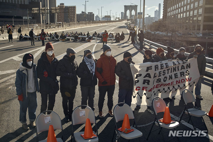 [뉴욕=AP/뉴시스] 친팔레스타인 시위대가 8일(현지시간) 미국 뉴욕 브루클린 다리에서 이스라엘-팔레스타인 전쟁 휴전을 촉구하는 시위를 하고 있다. 2024.01.09.