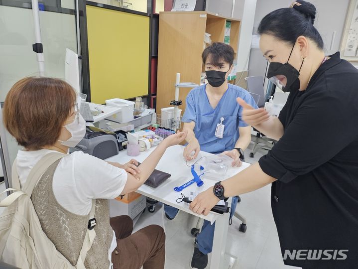 [서울=뉴시스]﻿﻿고려대학교 안암병원은 지난해 9월부터 진행한 수어 통역 서비스에 이어 의료기관 종사자를 대상으로 수어 교육 영상(이음소통)을 제작·배포했다고 15일 밝혔다. 의료수어 교육 동영상을 배포한 것은 국내 의료기관 중 고려대 안암병원이 처음이다. 수어통역사가 환자의 진료를 돕고 있다. (사진= 고려대 안암병원 제공) 2024.01.09. photo@newsis.com. 