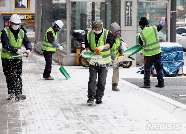 [서울=뉴시스] 김진아 기자 = 지난 9일 오전 서울 중구 명동역 인근에서 작업자들이 염화칼슘을 뿌리고 있다. 2024.01.26.