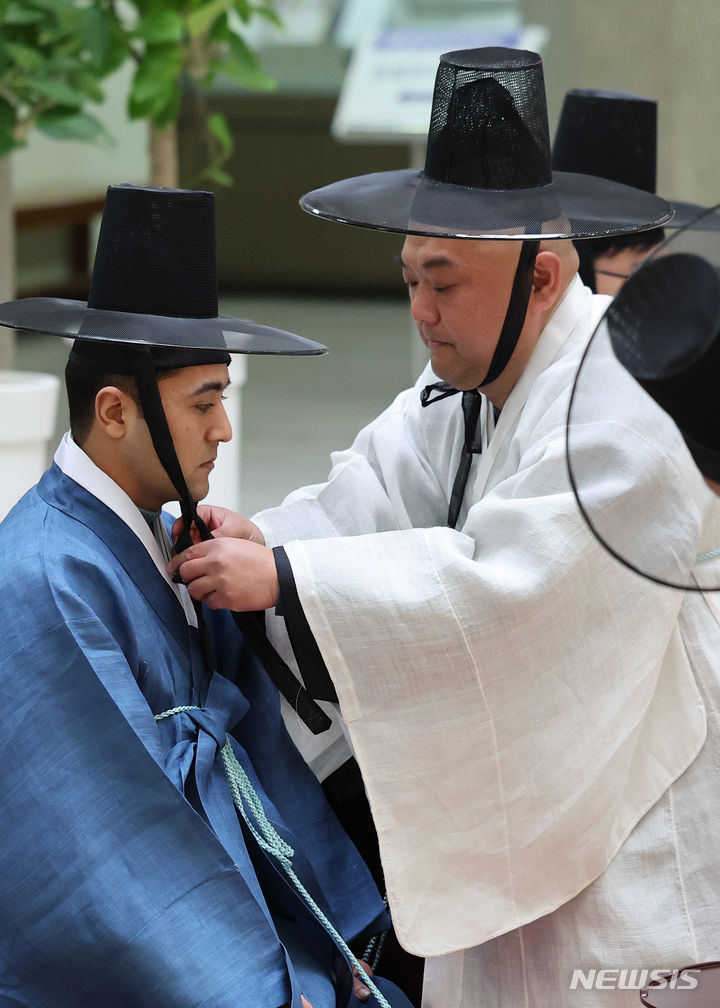 [경산=뉴시스] 이무열 기자 = 9일 경북 경산시 영남대학교 박물관에서 열린 영남대와 우즈베키스탄 사마르칸트국립대학교, 부하라국립대학교 문화교류 행사에서 우즈베키스탄 학생들이 한국 전통 성인식인 관례를 체험하고 있다. 2024.01.09. lmy@newsis.com