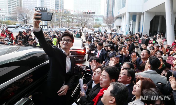 [부산=뉴시스] 하경민 기자 = 한동훈 국민의힘 비상대책위원장이 10일 오후 부산 해운대구 벡스코 컨벤션홀에서 부산시당 당원들과 간담회를 가진 뒤 차량에 오르면서 지지자들과 셀카를 찍고 있다. 2024.01.10. yulnetphoto@newsis.com