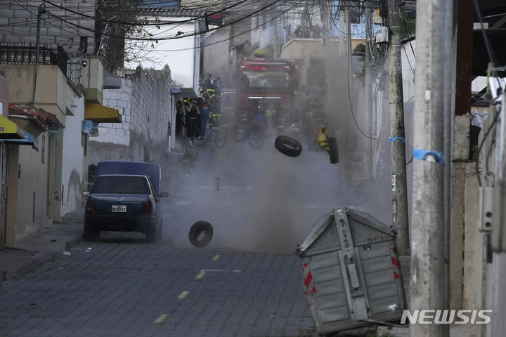 [키토=AP/뉴시스] 에콰도르 키토에서 경찰이 엘 잉카 교도소 인근에 버려진 수상한 차량 옆의 폭발물로 보이는 물체를 폭파하고 있다. 에콰도르 정부는 지난 해 1월 갱단 우두머리 아돌포 비야마르(일명 피토) 탈옥으로 사회 혼란이 발생하자 국가비상사태를 선포할 정도로 교도소 갱단들의 위력이 대단했다 2025.11.10.