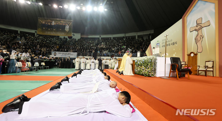 [전주=뉴시스] 김얼 기자 = 2024년 천주교 전주교구 사제·부제 서품식이 열린 11일 전북 전주시 전주실내체육관에서 서품을 받는 사제와 부제들이 부복 기도를 올리고 있다. 부복 기도는 세상에서 가장 낮은 이가 되어 하느님을 경배하겠다는 다짐을 상징한다. 2024.01.11. pmkeul@nwsis.com