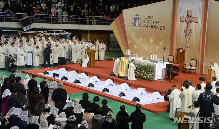 [전주=뉴시스] 김얼 기자 = 2024년 천주교 전주교구 사제·부제 서품식이 열린 11일 전북 전주시 전주실내체육관에서 서품을 받는 사제와 부제들이 부복 기도를 올리고 있다. 부복 기도는 세상에서 가장 낮은 이가 되어 하느님을 경배하겠다는 다짐을 상징한다. 2024.01.11. pmkeul@nwsis.com