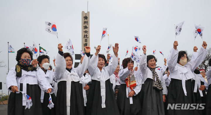 [제주=뉴시스] 우장호 기자 = 12일 오전 제주시 구좌읍 해녀항일운동기념탑 광장에서 열린 '제주해녀항일운동 제92주년 기념식' 추모제에서 해녀들이 만세삼창을 하고 있다. 2024.01.12. woo1223@newsis.com