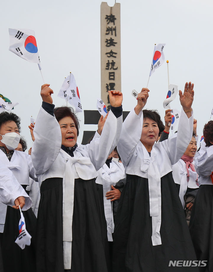 [제주=뉴시스] 우장호 기자 = 12일 오전 제주시 구좌읍 해녀항일운동기념탑 광장에서 열린 '제주해녀항일운동 제92주년 기념식' 추모제에서 해녀들이 만세삼창을 하고 있다. 2024.01.12. woo1223@newsis.com