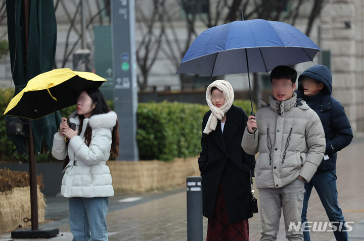 [서울=뉴시스] 김금보 기자 = 비가 내린 14일 오후 서울 중구 서울시청 인근에서 시민들이 우산을 쓰고 이동하고 있다. 기상청은 15일 서울 아침 최저기온이 -7도로 떨어지고 경기북부와 강원내륙·산지에선 영하 10도 이하로 떨어질 수 있다고 예보 했다. 2024.01.14. kgb@newsis.com