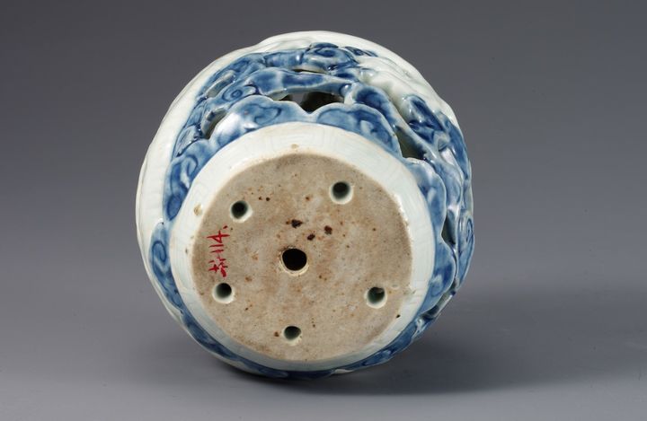 백자 청화 투각 구름 용무늬 연적. 밑바닥에는 작고 동그란 구멍이 다섯 개가 있는 것도 특징이다. 그중 네 개는 가장자리에 있어서 투조된 무늬와 맞통하며 한 개는 가운데에 있다. 관요가 경기도 광주시 남종면 분원리으로 옮겨간 소위 분원기(分院期) 초기의 작품으로, 태토가 정결하고 빙렬(氷裂) 없는 유약이 연한 청색을 머금어 청신하며 청화의 색이 곱고 밝다. 굽밑에 모래 받침 눈 자국이 있다. *재판매 및 DB 금지