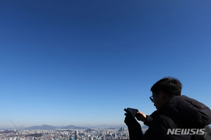 [서울=뉴시스] 홍효식 기자 = 전국이 대체로 맑은 날씨를 보인 15일 서울 중구 남산을 찾은 관광객이 스마트폰으로 파란 하늘과 서울 도심을 담고 있다. 2024.01.15. yesphoto@newsis.com