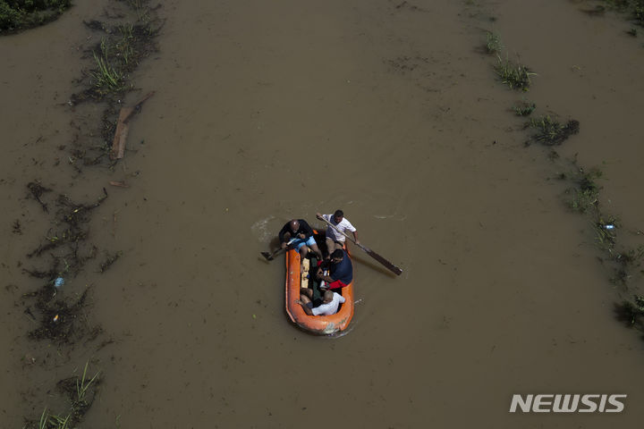 [ 두케 데 카시아스(브라질)= AP/뉴시스] 브라질 리우데자네이루 주의 홍수로 주민들이 14일 침수된 도로 위로 모터보트를 타고 대피하고 있다. 2024. 01. 16. 