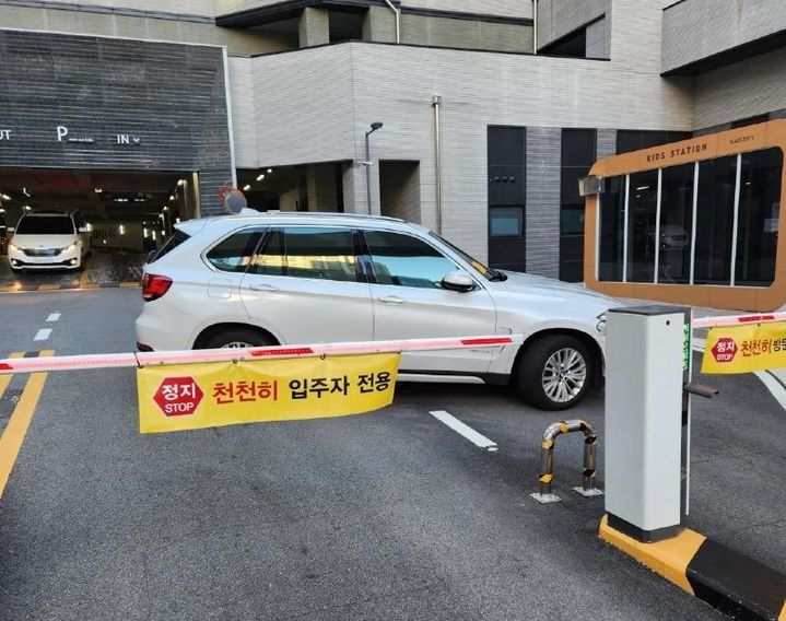 지난 14일 부산 해운대구 센텀시티의 한 아파트 입구 차단기 앞에 흰색 승용차 한 대가 비스듬히 주차된 사진이 온라인 커뮤니티를 통해 공개됐다. 입주자와 방문자 전용 입구를 모두 가로막은 탓에 다른 차들은 출구를 통해 드나들어야 했다. (사진='보배드림' 캡처본) *재판매 및 DB 금지