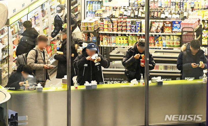 [수원=뉴시스] 김종택 기자 = 17일 경기도 수원시 한 편의점에서 직장들이 간편식으로 점심을 먹고 있다. 연일 치솟는 외식 물가로 식사비 지출을 줄이기 위해 도시락이나 간편식품으로 끼니를 해결하는 직장인들이 늘고 있다. 2024.01.17. jtk@newsis.com