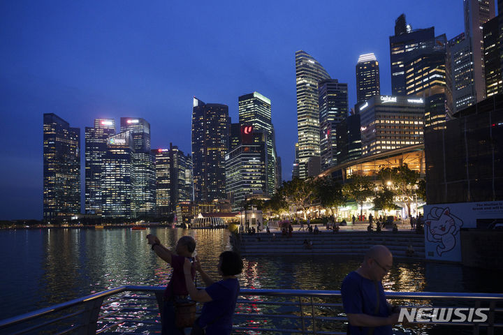 [싱가포르=AP/뉴시스]S 이스와란 싱가포르 교통부 장관이 18일 청렴국가로 유명한 싱가포르에서 장관급 부패 사건으로는 처음으로 기소됐다. 관광객들이 지난해 11월6일 싱가포르 스카이라인과 함께 사진을 찍고 있다.2024.01.18.