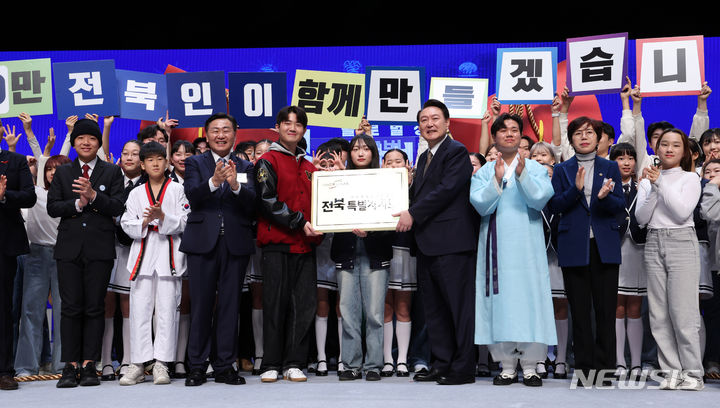 [전주=뉴시스] 전신 기자 = 윤석열 대통령이 18일 전주 덕진구 한국소리문화의전당 모악당에서 열린 전북특별자치도 출범식에서 미래세대들에게 전북특별자치도 명패를 전달하는 퍼포먼스를 하고 있다. (대통령실통신사진기자단) 2024.01.18. photo1006@newsis.com