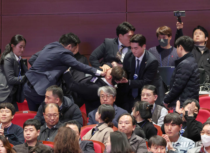 [전주=뉴시스] 전신 기자 = 강성희 진보당 의원이 18일 전주 덕진구 한국소리문화의전당 모악당에서 열린 전북특별자치도 출범식에서 윤석열 대통령이 참석자들과 인사하는 동안 경호원들에게 끌려 나가고 있다. 진보당측은 "강 의원이 윤 대통령과 악수하며 '국정기조를 바꾸지 않으면 국민들이 불행해집니다'라는 말을 건넨 순간 경호원들이 제지했다"고 주장했다. (대통령실통신사진기자단) 2024.01.18. photo1006@newsis.com