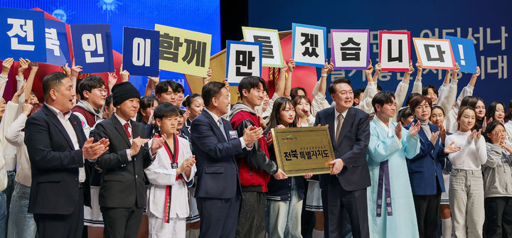 [전주=뉴시스] 윤석열 대통령이 18일 전주 덕진구 한국소리문화의전당 모악당에서 열린 전북특별자치도 출범식에서 미래세대들에게 전북특별자치도 명패를 전달하는 퍼포먼스를 하고 있다. (사진=대통령실 제공) 2024.01.18. photo@newsis.com *재판매 및 DB 금지