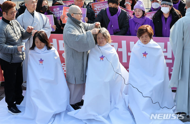 [서울=뉴시스] 최진석 기자 = 10.29 이태원 참사 유가족들이 18일 서울 용산 대통령실 앞에서 국민의힘 거부권 행사 건의에 대한 규탄 입장을 표명하는 삭발식을 하고 있다. 2024.01.18. myjs@newsis.com