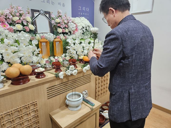 [서울=뉴시스] 오정우 기자 = 지난 17일 경기 고양시 서울시립승화원에서는 무연고 사망자를 위한 공영 장례가 치러졌다. 사진은 헌화를 하는 한 장례지도사. 2024.01.17 friend@newsis.com *재판매 및 DB 금지