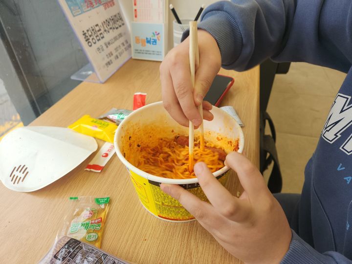 [수원=뉴시스] 이승주 기자 = 지난 17일 경기도 수원시 팔달구의 한 편의점에서 결식아동 함모(11)군이 라면과 소시지를 섞어서 먹고 있다. 2024.01.17. heyjude@newsis.com *재판매 및 DB 금지