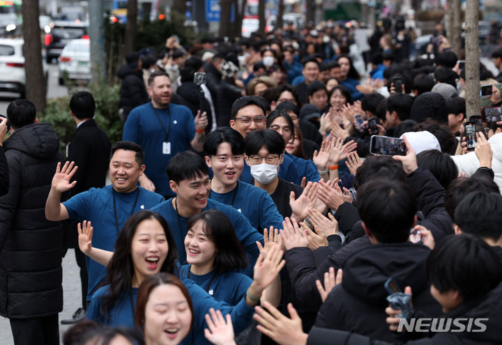[서울=뉴시스] 김명년 기자 = 20일 오전 서울 마포구 '애플 홍대' 오픈 행사에서 직원들이 기다리는 손님들과 하이파이브를 하며 인사를 나누고 있다. 2024.01.20. kmn@newsis.com