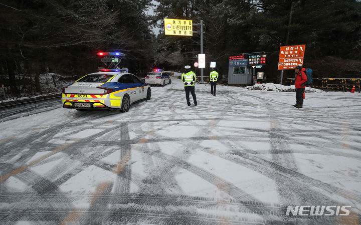 [제주=뉴시스] 우장호 기자 = 제주 산간에 대설특보가 내려진 22일 오전 한라산 1100도로로 연결되는 어승생 삼거리에서 경찰이 차량 진입을 통제하고 있다. 2024.01.22. woo1223@newsis.com