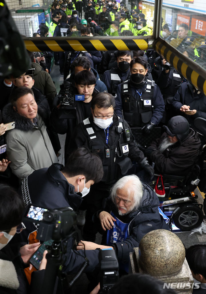 [서울=뉴시스] 김선웅 기자 = 전국장애인차별철폐연대 박경석 대표가 22일 서울 지하철 4호선 혜화역에서 장애인 이동권 보장을 촉구하는 중 발생한 몸싸움 후 통증을 호소하며 출동한 119구급대원에게 조치를 받고 있다. 2024.01.22. mangusta@newsis.com