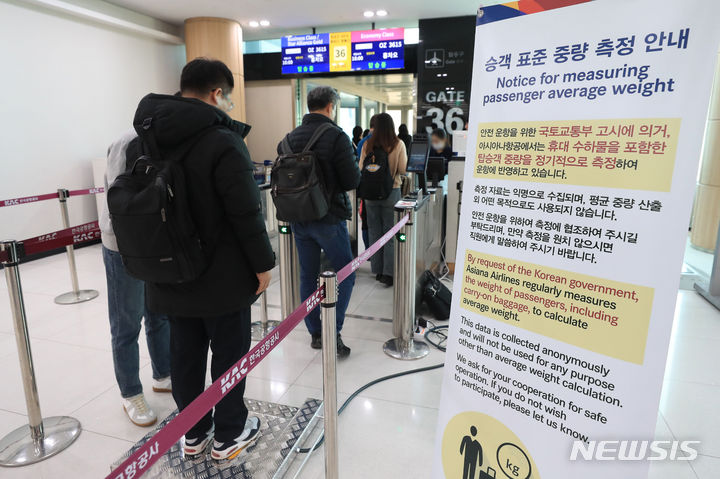 [서울=뉴시스] 공항사진기자단 = 22일 김포국제공항 국제선 출국장에서 한 탑승객이 몸무게를 측정받고 있다. 아시아나항공은 승객 표준 중량 측정을 위해 오는 31일까지 국제선 항공기에 탑승하는 승객들의 몸무게를 측정한다. 승객 표준 중량은 국토교통부 '항공기 중량 및 평형 관리기준'에 따라 항공사들마다 최소 5년마다 혹은 필요시 승객 표준 중량을 측정한다. 측정 값은 익명으로 기록되며 원하지 않으면 거부할 수 있다. 2024.01.22. photo@newsis.com