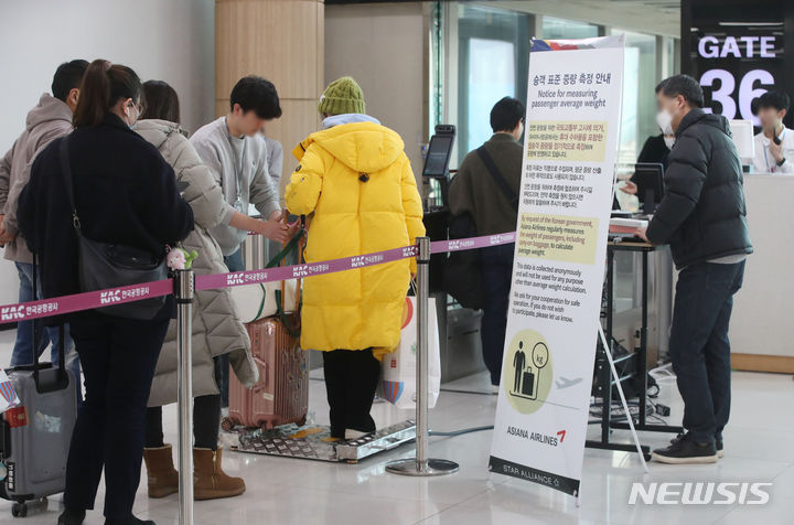 [서울=뉴시스] 공항사진기자단 = 22일 김포국제공항 국제선 출국장에서 한 탑승객이 몸무게를 측정받고 있다. 아시아나항공은 승객 표준 중량 측정을 위해 오는 31일까지 국제선 항공기에 탑승하는 승객들의 몸무게를 측정한다. 승객 표준 중량은 국토교통부 '항공기 중량 및 평형 관리기준'에 따라 항공사들마다 최소 5년마다 혹은 필요시 승객 표준 중량을 측정한다. 측정 값은 익명으로 기록되며 원하지 않으면 거부할 수 있다. 2024.01.22. photo@newsis.com