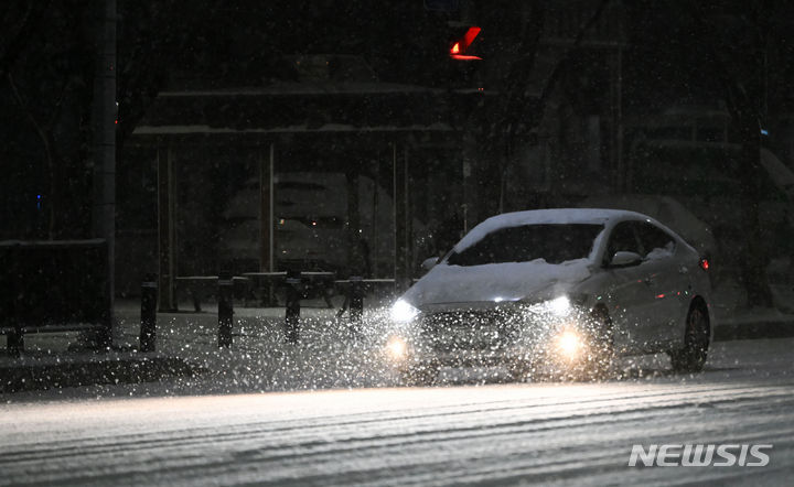 [광주=뉴시스] 이영주 기자 = 광주지역에 대설주의보가 내려진 22일 오후 광주 서구 서부경찰서 주변 도로에서 한 차량이 눈을 맞으며 서행하고 있다. 2024.01.22. leeyj2578@newsis.com