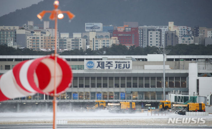 [제주=뉴시스] 우장호 기자 = 올해들어 가장 추운 날씨를 보이는 23일 오전 폭설로 인해 운항이 중단된 제주국제공항 활주로에서 제설차가 쌓인 눈을 치우고 있다. 2024.01.23. woo1223@newsis.com