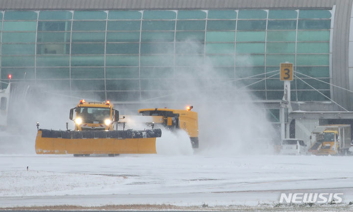 [제주=뉴시스] 우장호 기자 = 올해들어 가장 추운 날씨를 보이는 23일 오전 폭설로 인해 운항이 중단된 제주국제공항 활주로에서 제설차가 쌓인 눈을 치우고 있다. 2024.01.23. woo1223@newsis.com