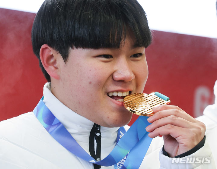[평창=뉴시스] 황준선 기자 = 23일 강원 평창군 올림픽 슬라이딩 센터에서 열린 2024 강원동계청소년올림픽 대회 남자 봅슬레이 모노봅에서 금메달을 차지한 한국 소재환이 메달 시상식에서 금메달을 입에 물고 있다. 2024.01.23. hwang@newsis.com