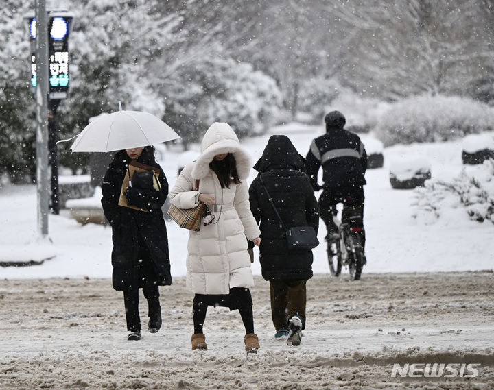 [광주=뉴시스] 박기웅 기자 = 화요일인 오는 6일은 아침까지 전국 대부분 지역에 비 또는 눈이 오겠고, 특히 강원영동과 경북북동산지, 경북북부동해안을 중심으로 많은 눈이 오겠다. 사진은 지난달 24일 오전 광주 서구 쌍촌동 운천저수지 앞 횡단보도에서 시민들이 도로 위에 쌓인 눈을 피해 조심스레 길을 건너고 있는 모습. 2024.01.24. pboxer@newsis.com